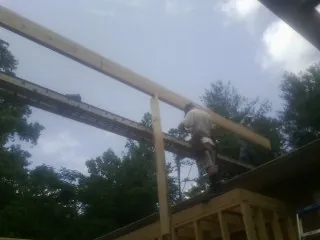 Carpenter setting a ridge beam over a new addition frame — Ice Dam Removal by Roofing Brothers in Ponca City