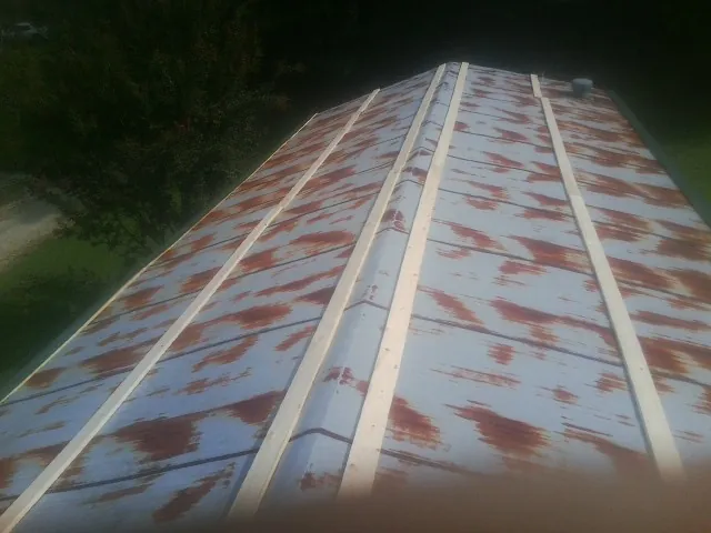 Rusted metal roof panels with new wood purlins before replacement — Storm Damage Roof Repair in Ponca City by Roofing Brothers