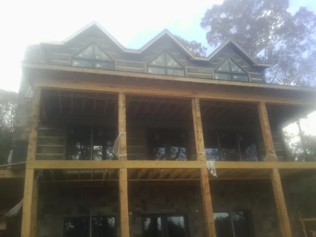 Dormers and porch framing on a large log home under construction — Roof Coating work by our crew in Ponca City