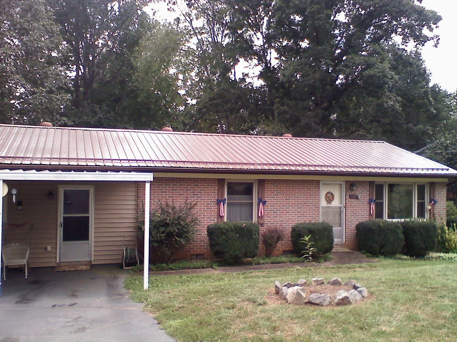 Bronze metal roof and carport on a brick ranch home — Roof Repair work by our crew in Ponca City