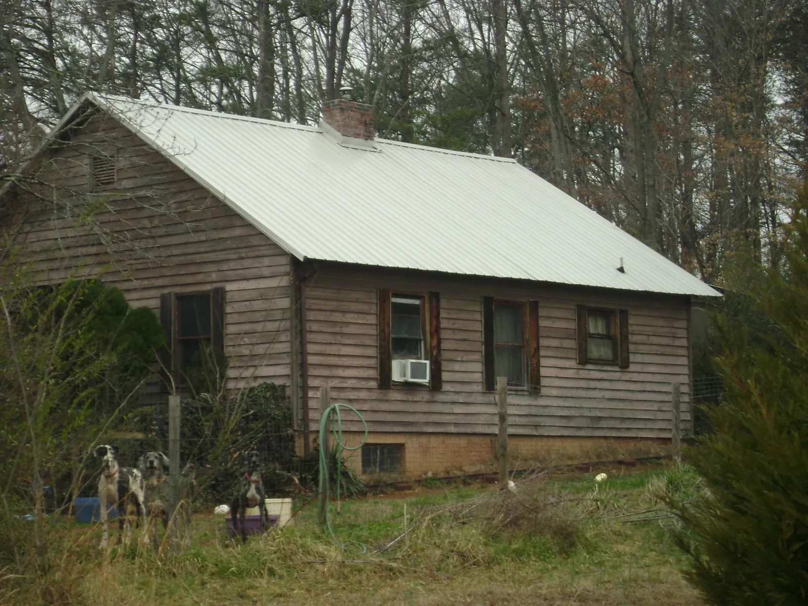 White metal roof on an old wood sided farmhouse, from a Metal Roof Installation job in Ponca City